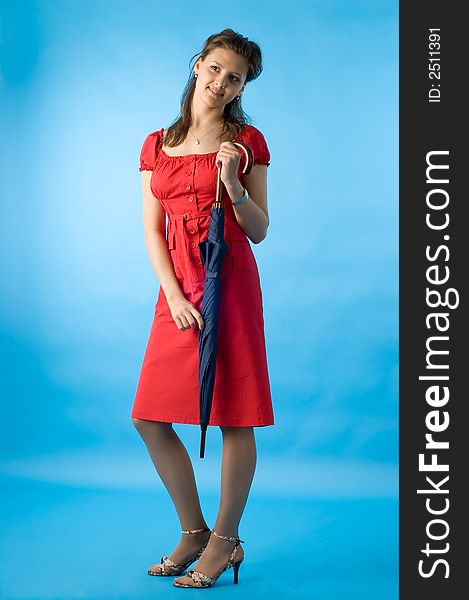 The girl in a red dress on a dark blue background with a umbrella. The girl in a red dress on a dark blue background with a umbrella