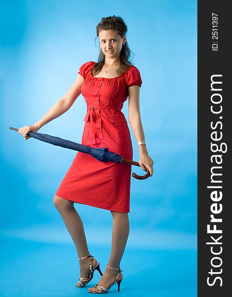 The girl in a red dress on a dark blue background with a umbrella. The girl in a red dress on a dark blue background with a umbrella