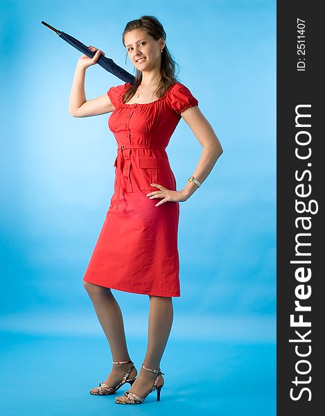 The girl in a red dress on a dark blue background with a umbrella. The girl in a red dress on a dark blue background with a umbrella