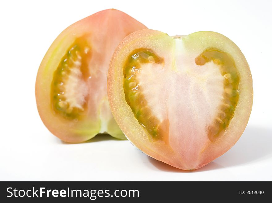 One tomato cutted with heart-shaped on white. One tomato cutted with heart-shaped on white
