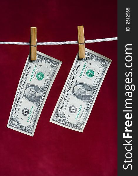 Two american dollar attach to rope clothes peg on red