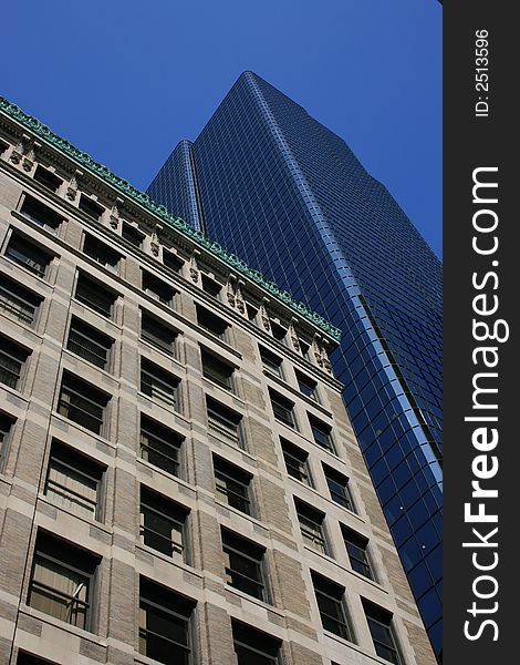 Modern, glass office tower next to an older, brick one.  Boston. Modern, glass office tower next to an older, brick one.  Boston.