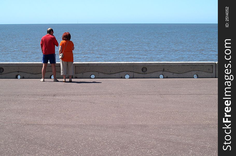 Couple looking out to sea from promenade