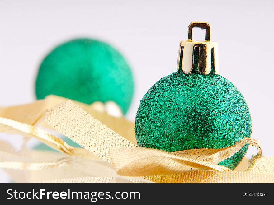 Two balls of green color and golden tape, New Year's toy. Two balls of green color and golden tape, New Year's toy