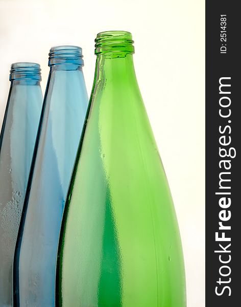 Bottles from glass of green and dark blue color on white background