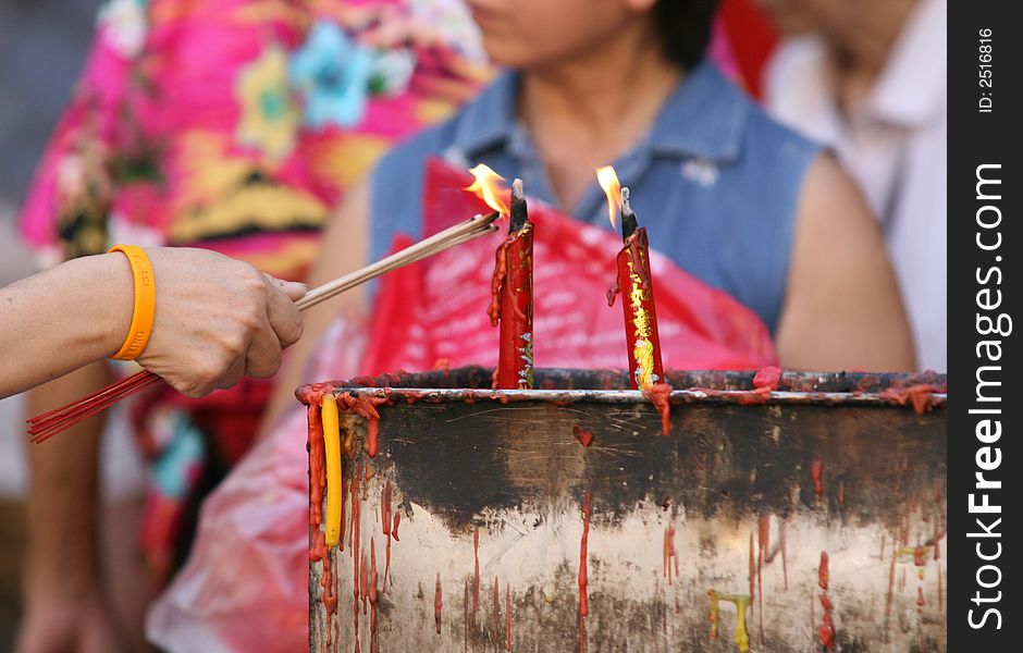 Burning incense and candles in a temple to bring good luck at Chinese New Year. Burning incense and candles in a temple to bring good luck at Chinese New Year