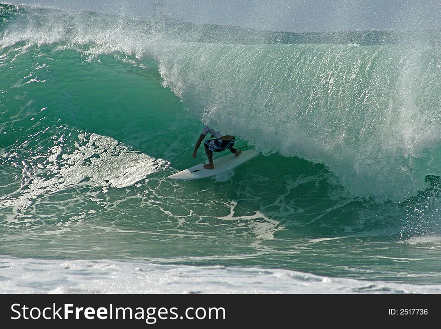 A male surfer riding a wave. A male surfer riding a wave