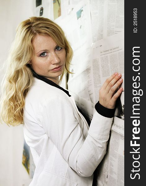 Portrait of a fresh and beautiful blond woman with a lot of newspapers. Portrait of a fresh and beautiful blond woman with a lot of newspapers