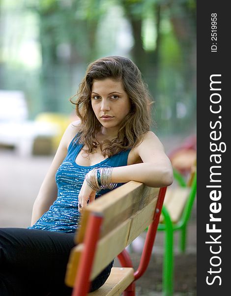 Beautiful woman sitting on a seat at park. Beautiful woman sitting on a seat at park