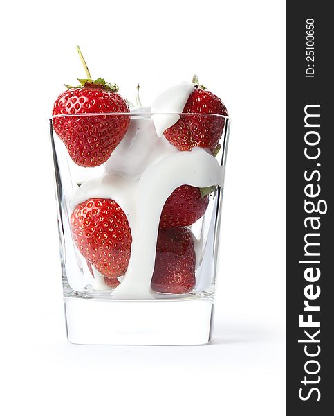 Ripe strawberries and milk in a beaker on a white background