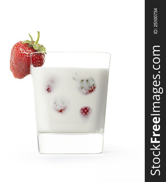 Ripe strawberries and milk in a beaker on a white background