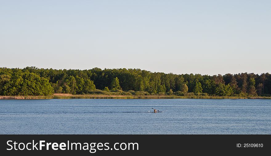 Blue sky and green trees in nature over lake with reflections