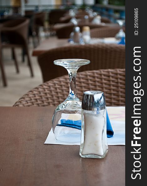 Glass and salt cellar in outdoors cafe