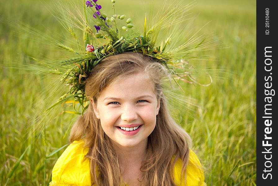 Beautiful little girl on the meadow. A wreath of wheat ears and wild flowers is on her blonde hair. Beautiful little girl on the meadow. A wreath of wheat ears and wild flowers is on her blonde hair