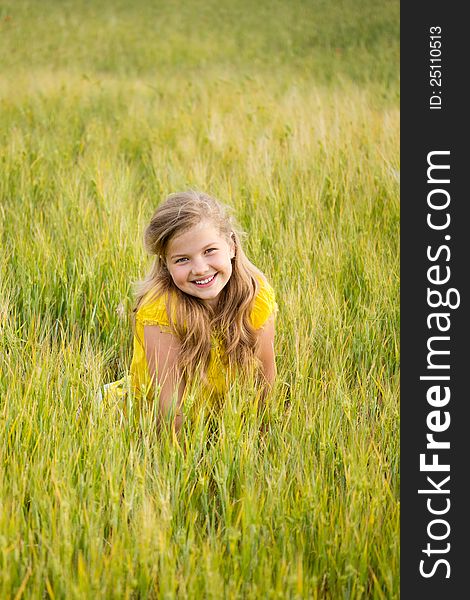 Beautiful little girl with blonde long hair on the meadow. Beautiful little girl with blonde long hair on the meadow.