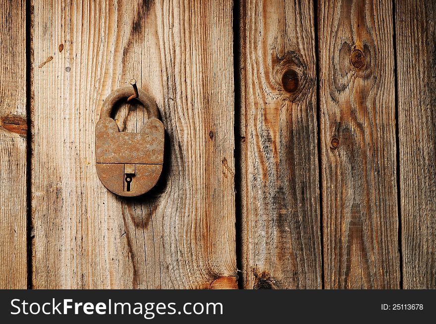 Old rusty padlock hanging on wooden wall. Old rusty padlock hanging on wooden wall
