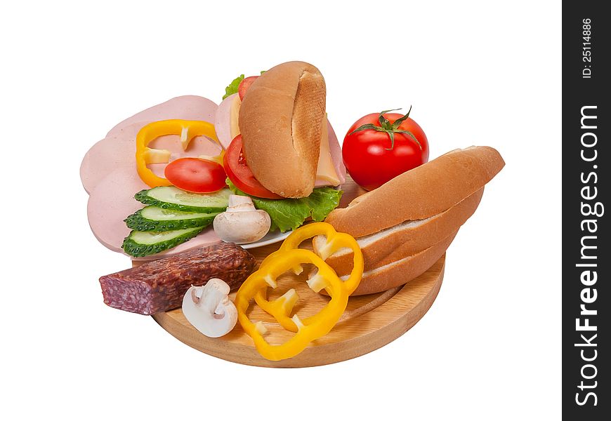 Sandwich with sausage and vegetables on plate, bread and vegetables on cutting board isolated on white background