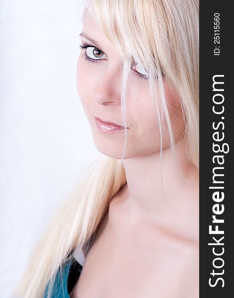 High key portrait of attractive young woman with long blond hair, studio background.