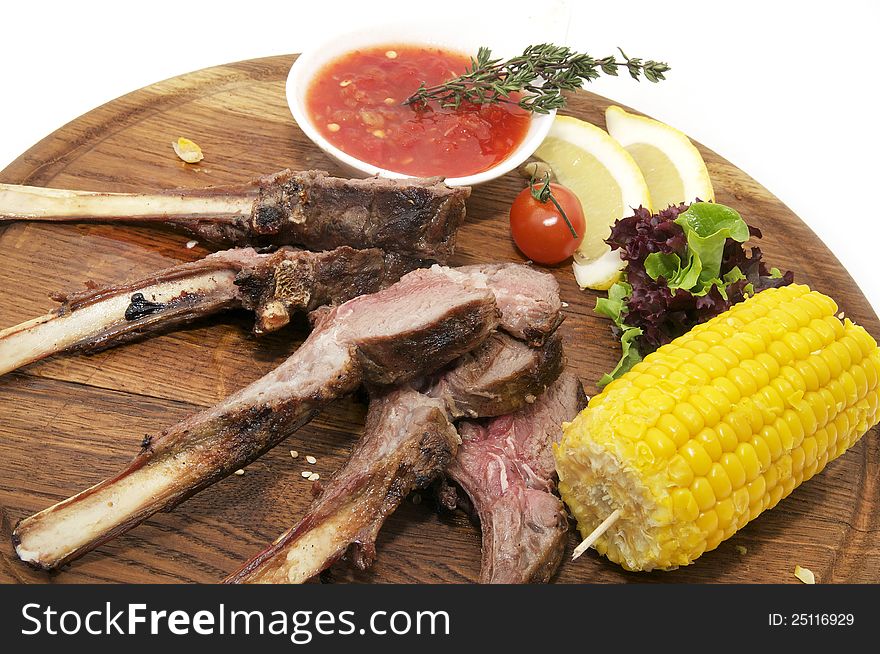 Fried pork ribs with sauce and corn on a white background