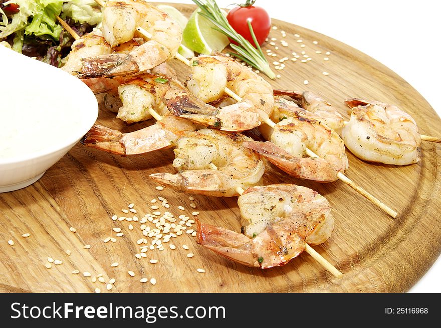 Grilled shrimp with a salad on a wooden plate