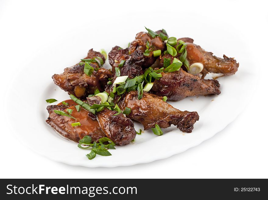 Fried chicken legs with green onions on plate