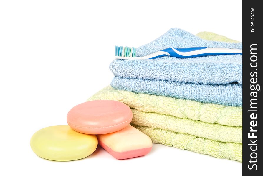 Tooth brush on the pile of towels and soap