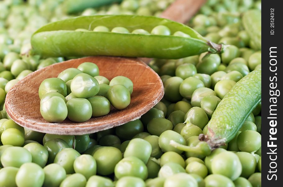 Fresh raw green pea seeds on wooden spoon,close up. Fresh raw green pea seeds on wooden spoon,close up