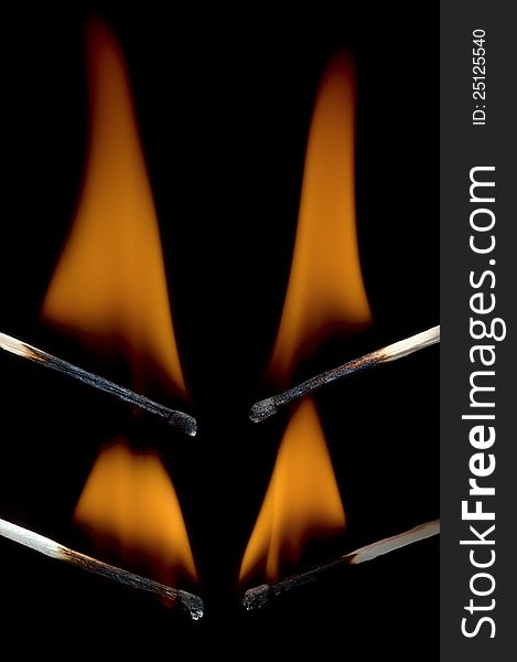 Burning matchstick on black background