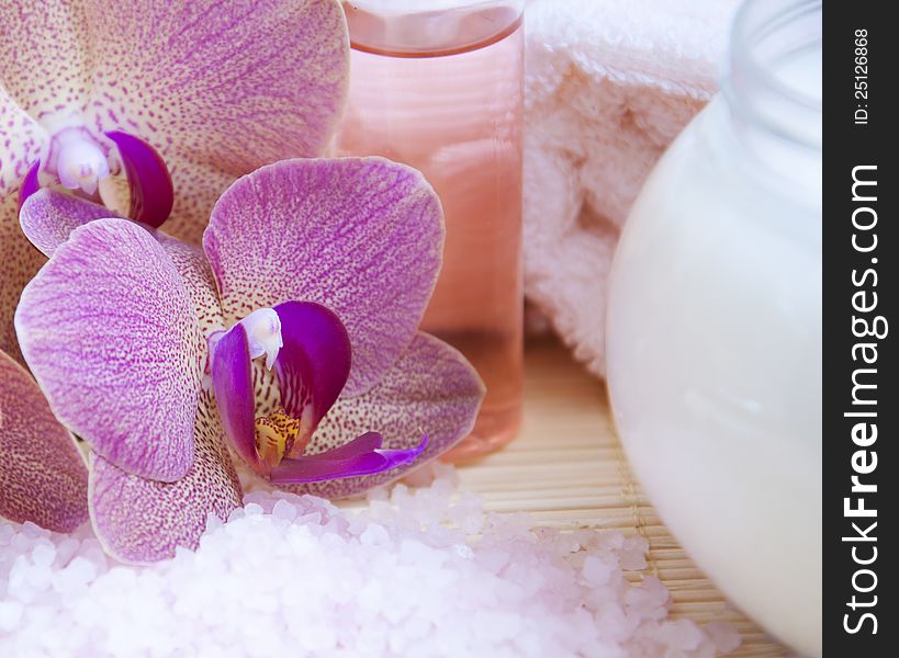 Cream with pink orchids towel and sea salt. Cream with pink orchids towel and sea salt
