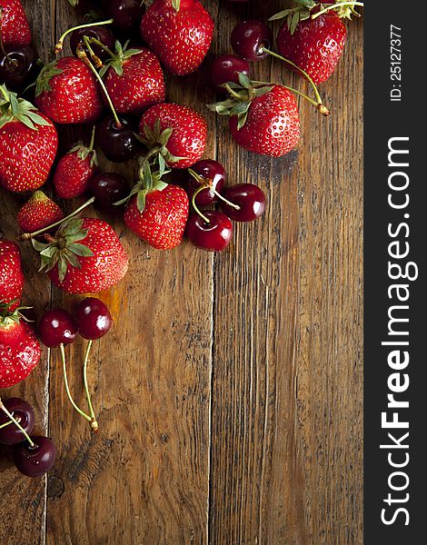 Ripe, juicy, red strawberries, cherries on wooden background. Ripe, juicy, red strawberries, cherries on wooden background