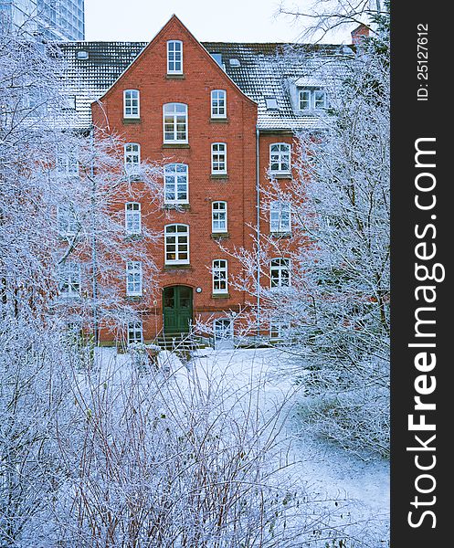 Old histirical brick apartment house in the winter season with frozen plants. Old histirical brick apartment house in the winter season with frozen plants.