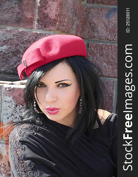 Portrait of the beautiful young brunette wearing crimson hat. Portrait of the beautiful young brunette wearing crimson hat