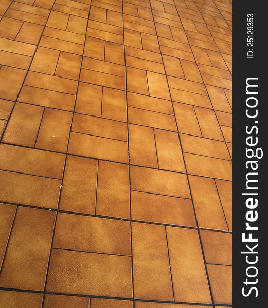 An orange brown square tiled floor. An orange brown square tiled floor