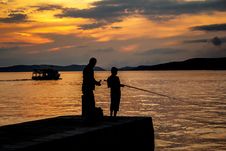 Silhouettes Of Father And His Son Fishing On Sea Royalty Free Stock Photography