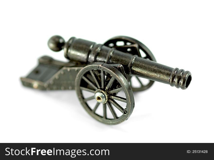 A miniature model of an old cannon on a white background. Close-up. A miniature model of an old cannon on a white background. Close-up
