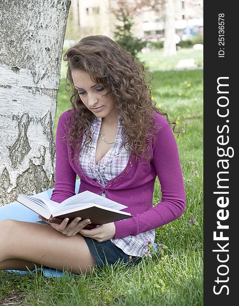 Young woman in park holding a book. Young woman in park holding a book