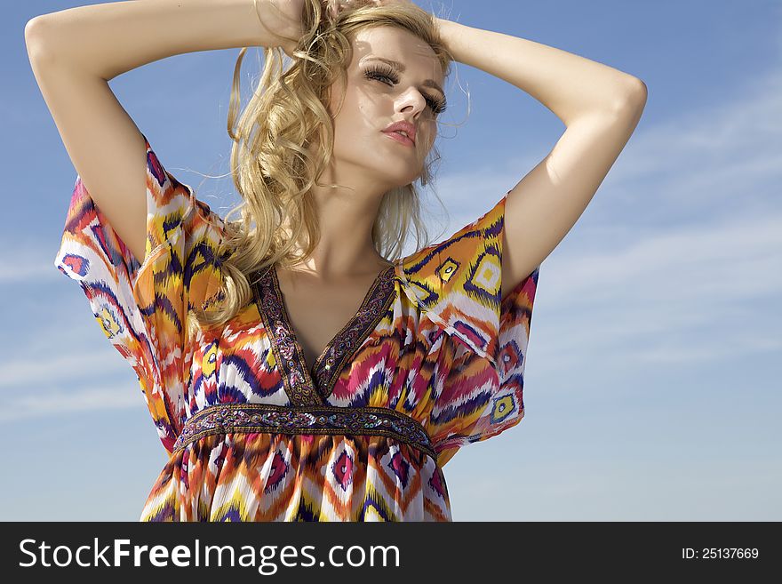 Portrait of beautiful blonde girl on background blue sky. Portrait of beautiful blonde girl on background blue sky