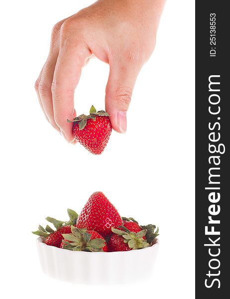 Hand taking strawberry out of bowl. Hand taking strawberry out of bowl