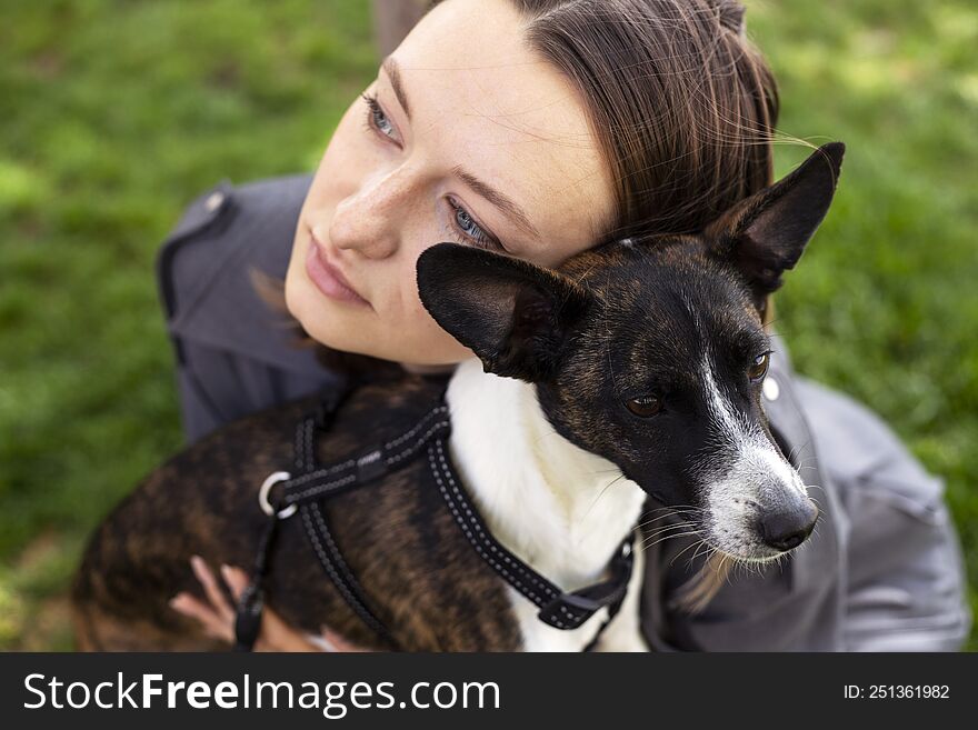 Optimistic Woman In Grey Suit Smiling And Playing With Dog.