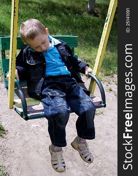 Little boy fell asleep in the swing riding. Little boy fell asleep in the swing riding