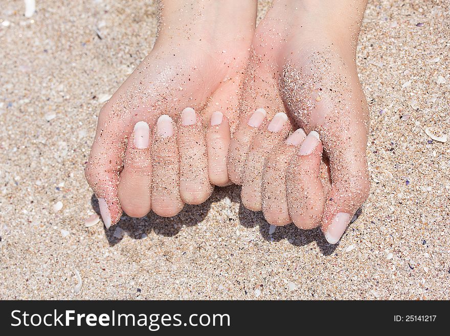 Nice hands with manicure in sand. Nice hands with manicure in sand