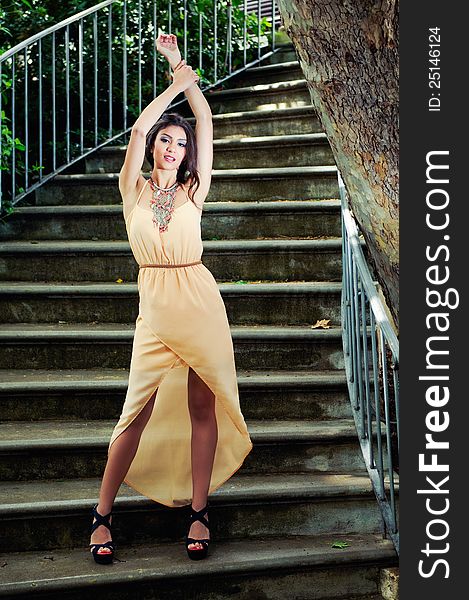 Beautiful young woman in a garden stairs.