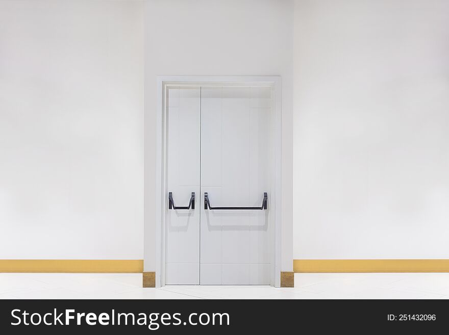 White double door with a bevelled white wall in empty room. White wall with a door