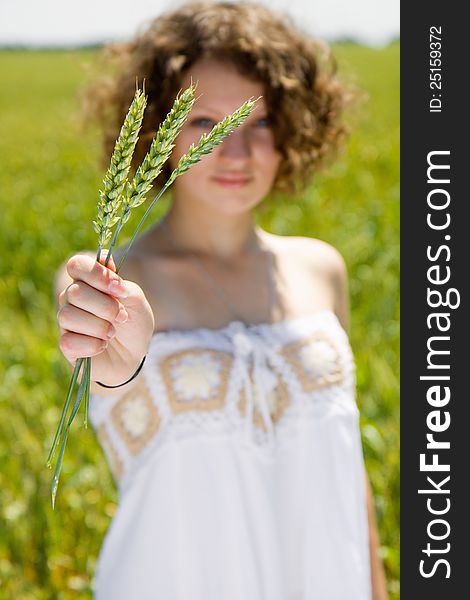 Young girl holding a ear of wheat