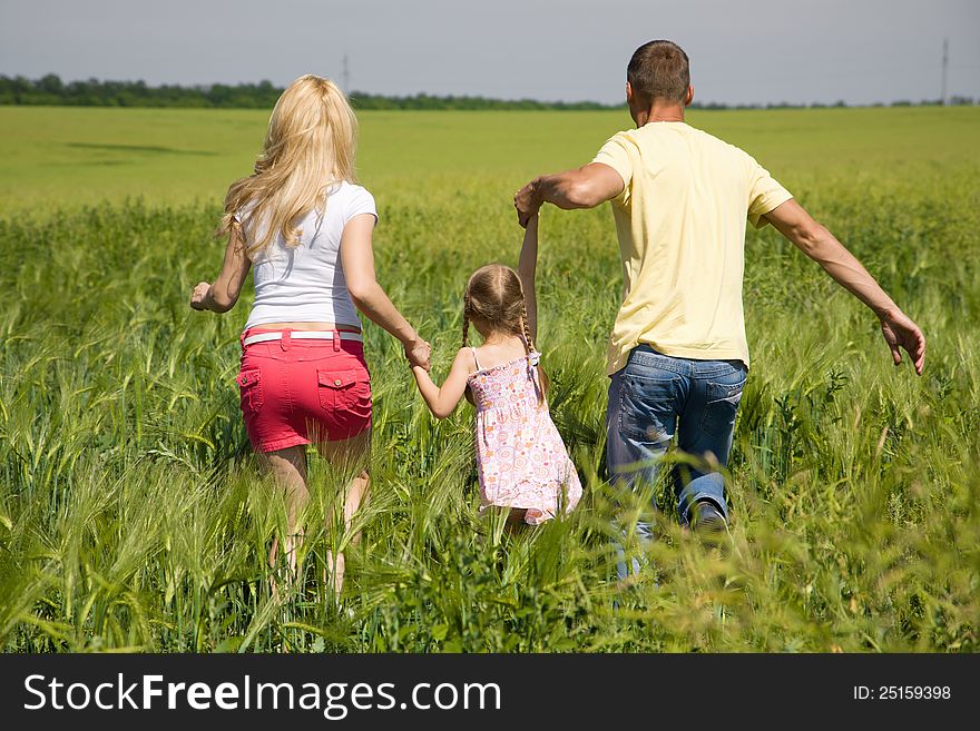 A young family running across the field