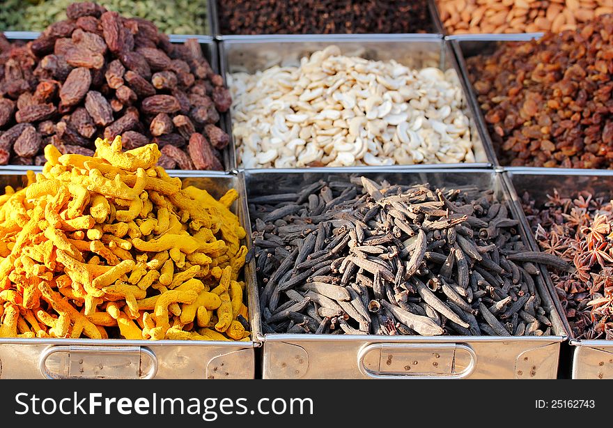 Dry fruits and spices like cashews, raisins, turmeric, cloves, anise, etc. on display in containers for sale in a bazaar in bangalore, india. Dry fruits and spices like cashews, raisins, turmeric, cloves, anise, etc. on display in containers for sale in a bazaar in bangalore, india.