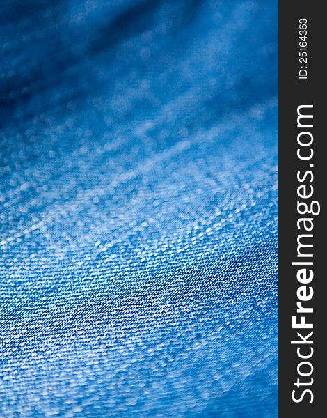 Closeup texture of blue denim jeans material showing the detail and texture of the weave. Closeup texture of blue denim jeans material showing the detail and texture of the weave