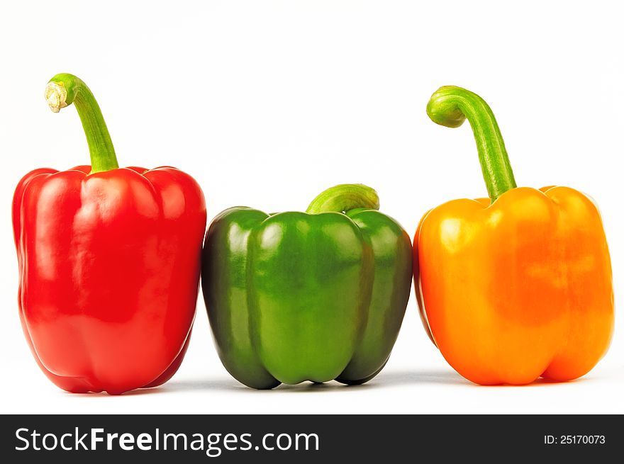 Three luscious colored peppers are on white background. Three luscious colored peppers are on white background