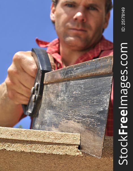 Inferior shot of hard working man sawing wood outdoors. Inferior shot of hard working man sawing wood outdoors