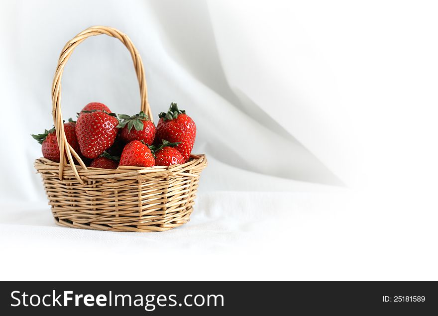 Nice wicker basket full of freshness red strawberry on white cloth background. Nice wicker basket full of freshness red strawberry on white cloth background